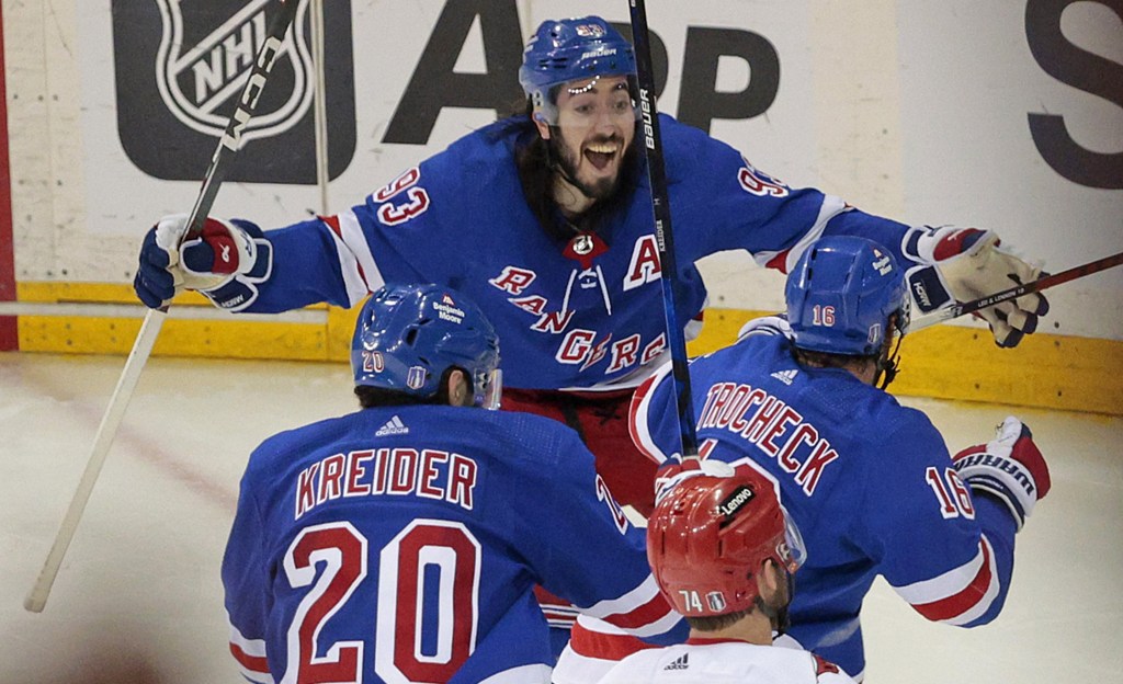 A smiling Mika Zibanejad and Chris Kreider (left) celebrate after Vincent Trocheck (right) scored the game-winning goal in the Rangers' 4-3 double overtime win over the Hurricanes in Game 2.