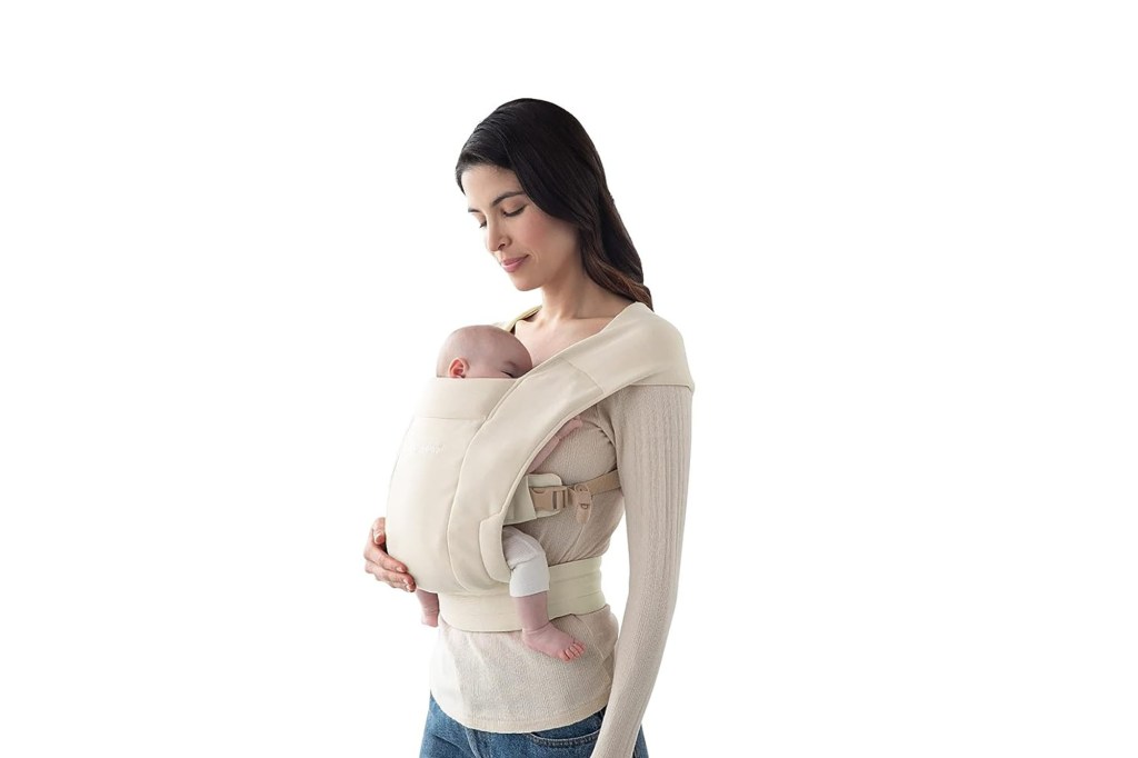 A woman holding a baby in a baby carrier