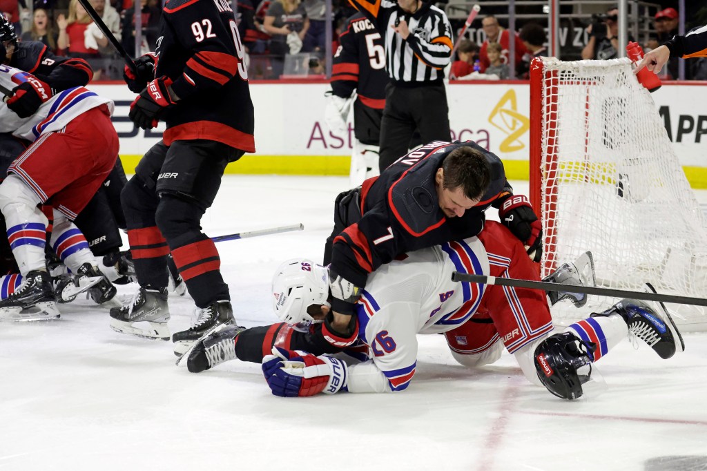 Hurricanes defenseman Dmitry Orlov (7) wrestles New York Rangers left wing Jimmy Vesey (26) to the ic