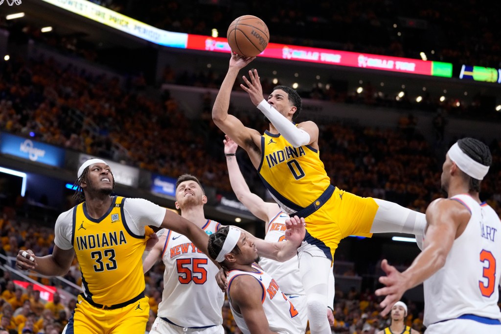 Indiana Pacers guard Tyrese Haliburton (0) is fouled by New York Knicks guard Miles McBride while driving to the basket during the second half of Game 3