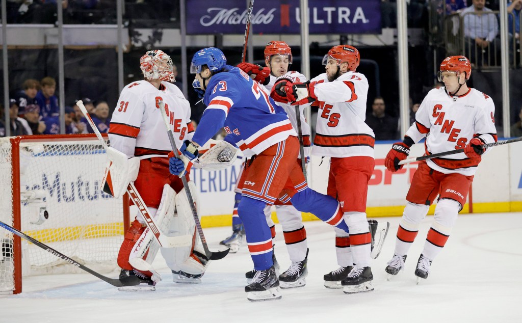 Hurricanes defenseman Tony DeAngelo pushes New York Rangers center Matt Rempe from the back in the first period