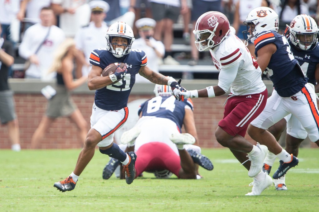 Brian Battie looks to run the ball by linebacker Gerrell Johnson #22 of the Massachusetts Minutemen at Jordan-Hare Stadium on September 02, 2023.