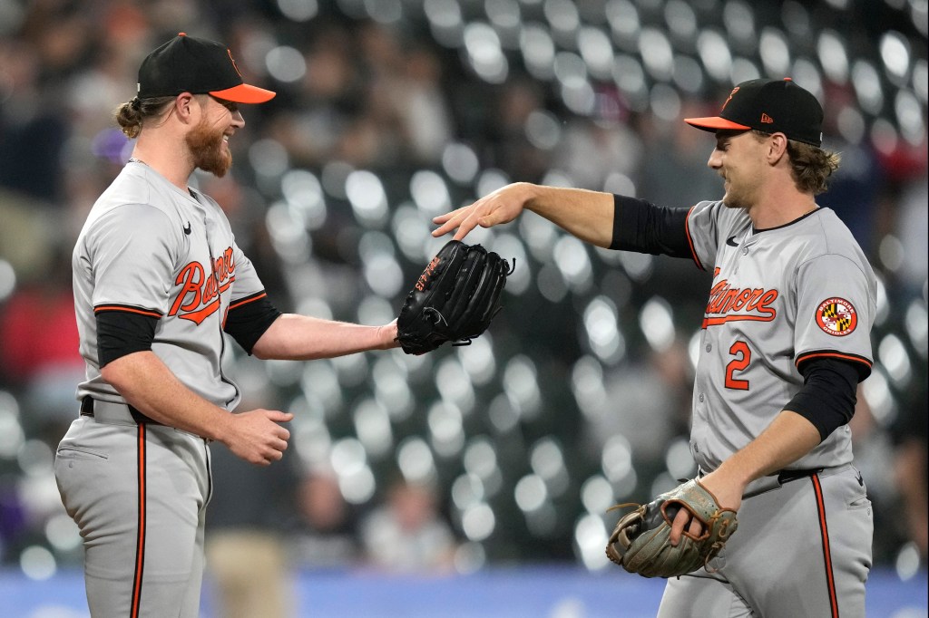 Baltimore Orioles shortstop Gunnar Henderson, right, gives relief pitcher Craig Kimbrel the game ball after the Orioles defeated the Chicago White Sox