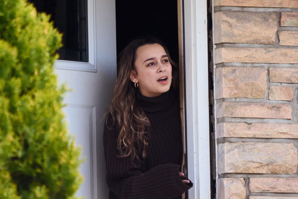 A woman poking her head out of a door.