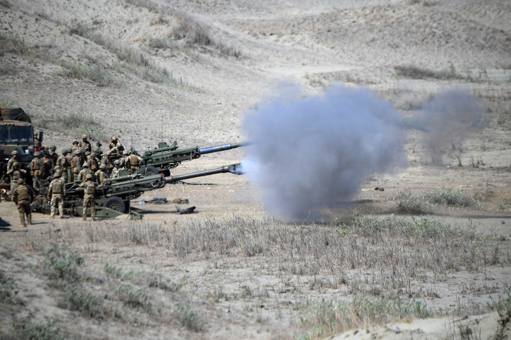 US and Philippine Marines fire M198 155mm Howitzer artillery during a live fire exercise against an imaginary "invasion" force as part of the joint US-Philippines annual military Balikatan drills on a strip of sand dunes in Laoag on Luzon island's northwest coast on May 6, 2024.