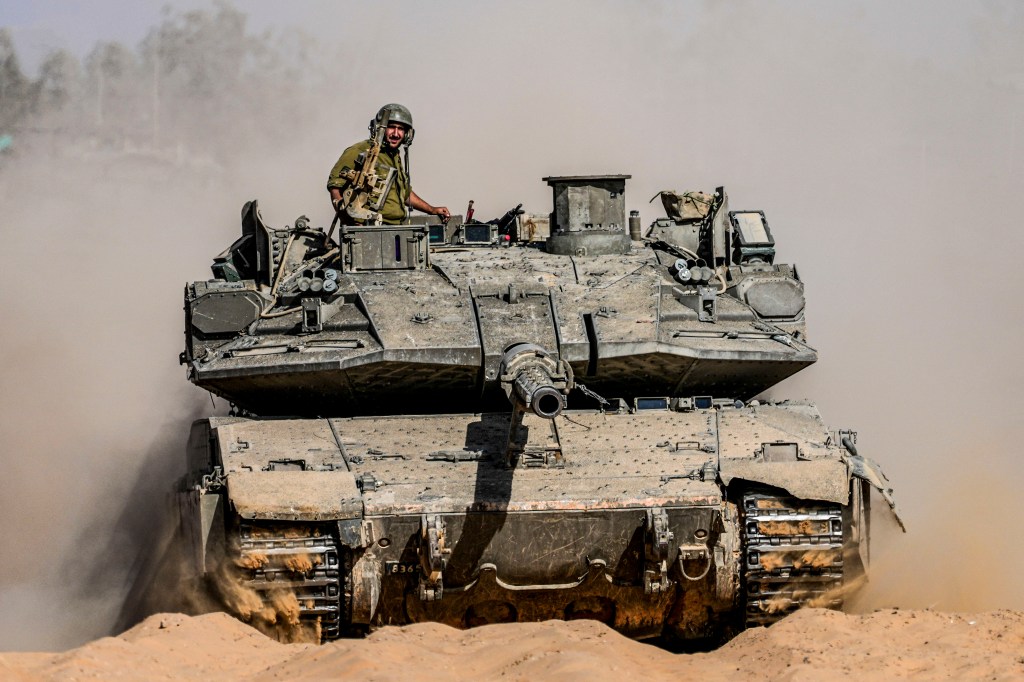 Israeli soldiers driving a tank near the border with the Gaza Strip on May 5, 2024.