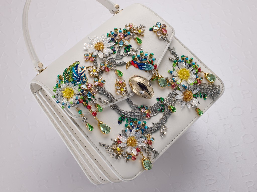 Bulgari's Serpenti collection bag designed by Mary Katrantzou, featuring a white purse adorned with colorful flowers.