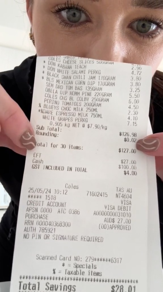 A person holding a grocery receipt from Coles supermarket