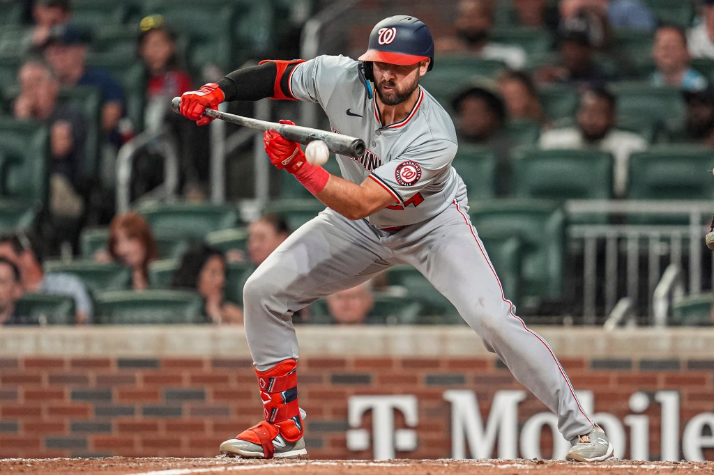 Nationals first baseman Joey Gallo (24) bunts for a single against the Atlanta Braves during the eighth inning at Truist Park. 