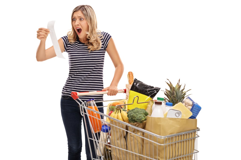 Stock photo of woman looking at a store receipt.