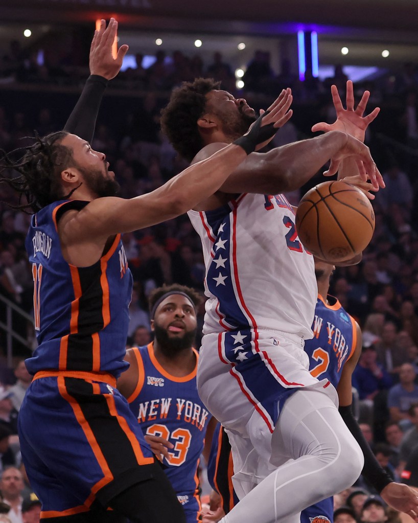 Philadelphia 76ers center Joel Embiid (21) is fouled by New York Knicks guard Miles McBride (2) as he drives to the basket against Knicks center Mitchell Robinson (23) and guard Jalen Brunson (11) during the first quarter of game 5 of the first round of the 2024 NBA playoffs at Madison Square Garden.