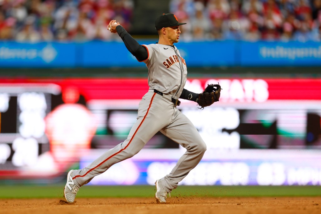 Giants shortstop Nick Ahmed airmails a throw in the second inning on Sunday.