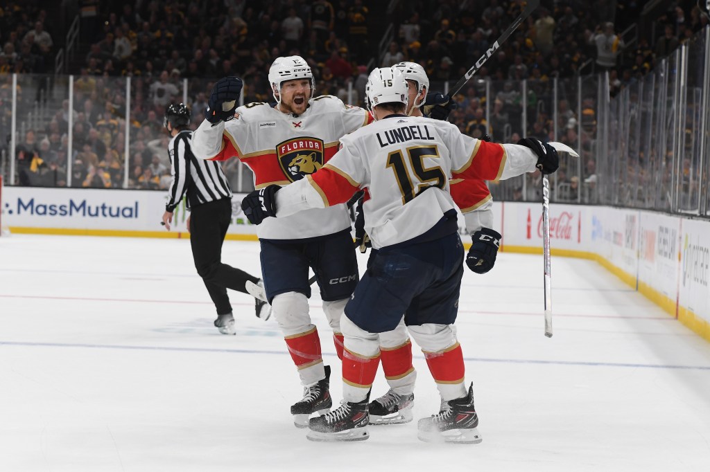 Sam Reinhart #13, Gustav Forsling #42 and Anton Lundell #15 of the Florida Panthers celebrate the third-period goal against the Boston Bruins in Game Six