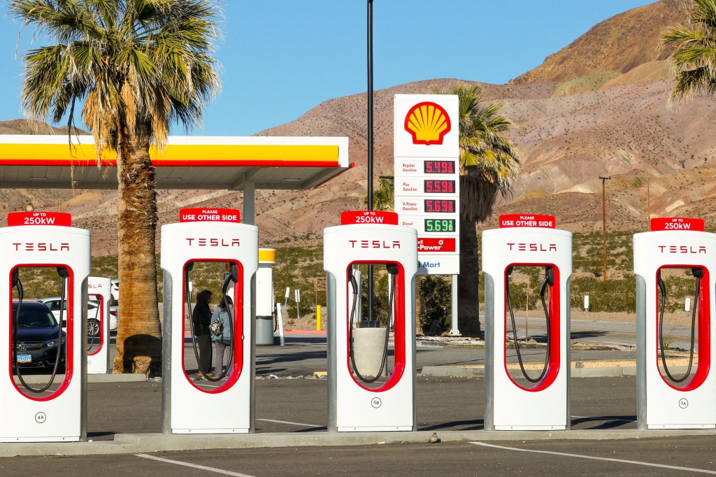 Tesla supercharging station next to a traditional gas station in Yermo, California, U.S., taken on February 12, 2024.