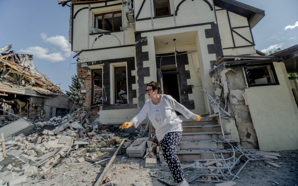 A woman walks in front of homes hit by Russian bombs in the city of Belgorod on May 5.