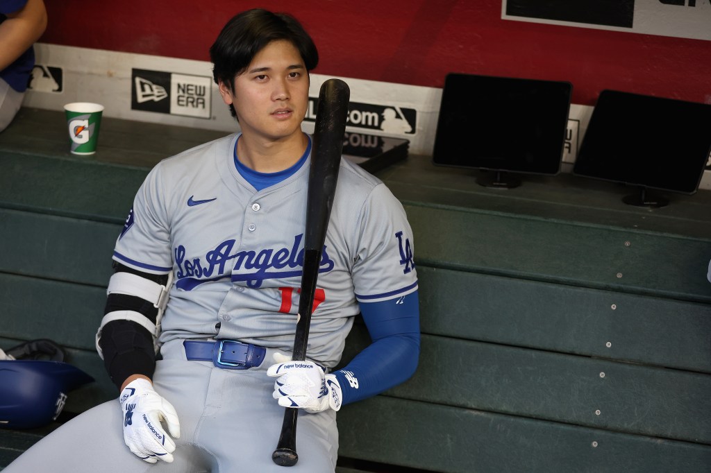 Shohei Ohtani #17 of the Los Angeles Dodgers sits in the dugout during a delay to the MLB game against the Arizona Diamondbacks at Chase Field on April 30, 2024 in Phoenix, Arizona. 