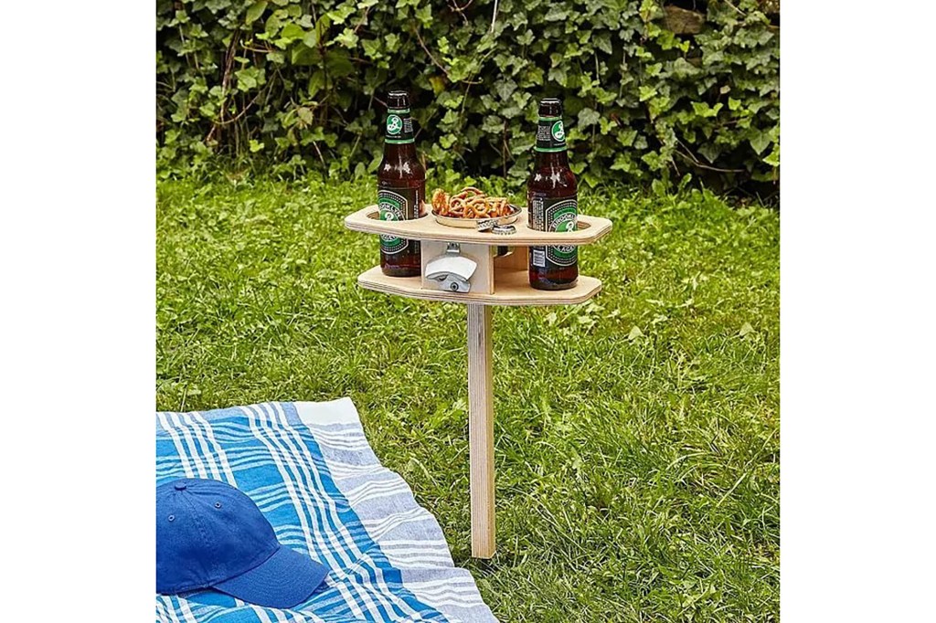 A picnic table with beer bottles and snacks on it