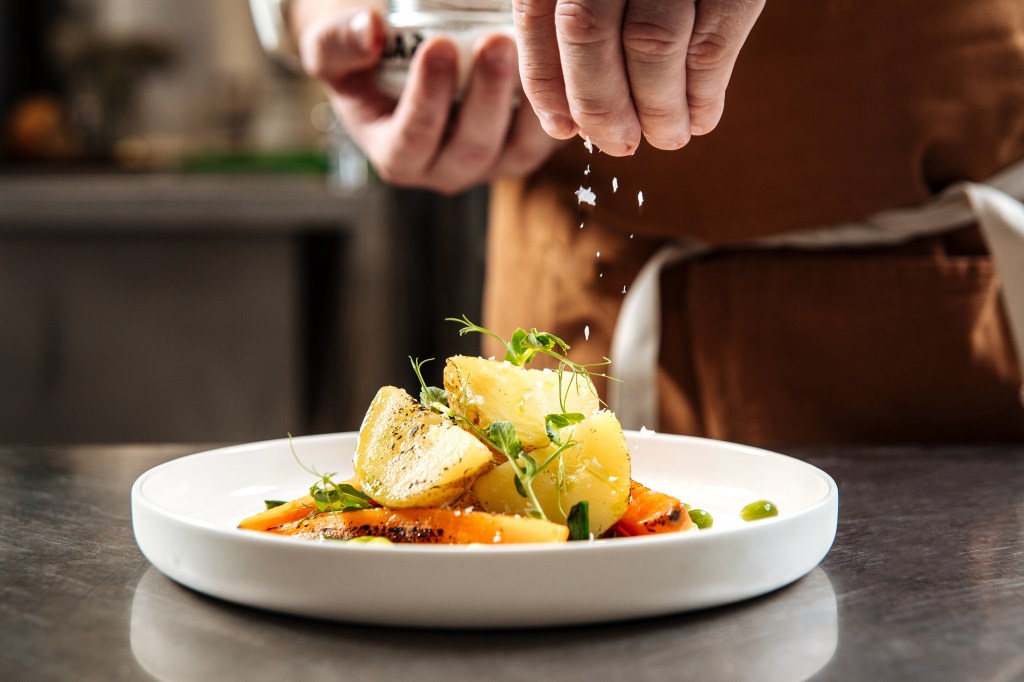 sprinkling salt over a dish