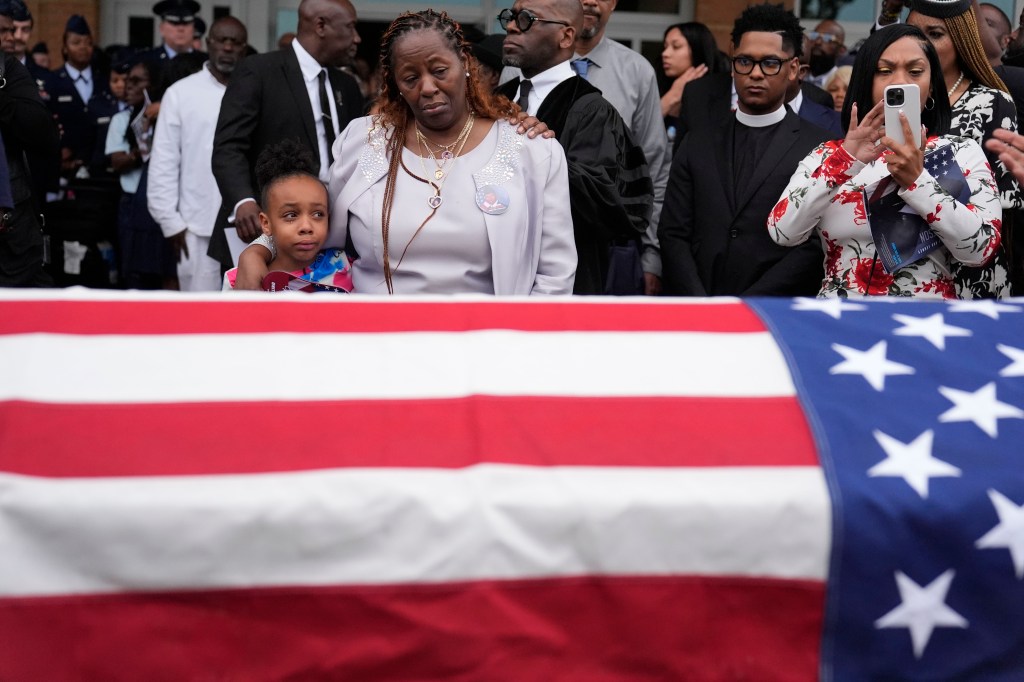 Chantemekki Fortson the mother of slain airman Roger Fortson, right, along with family watch Fortson's casket as they leave for a cemetery during his funeral at New Birth Missionary Baptist Church, Friday, May 17, 2024, in Stonecrest, Ga.