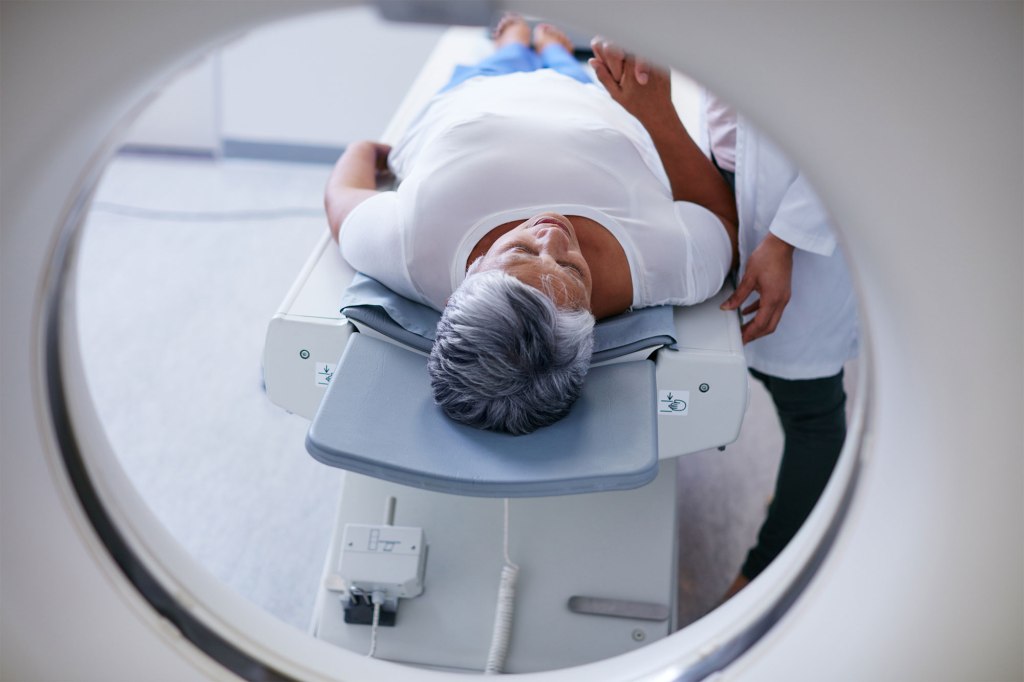 A person lying on a medical table, representing the concept of wealthy people at a greater risk of cancer than the less well-off