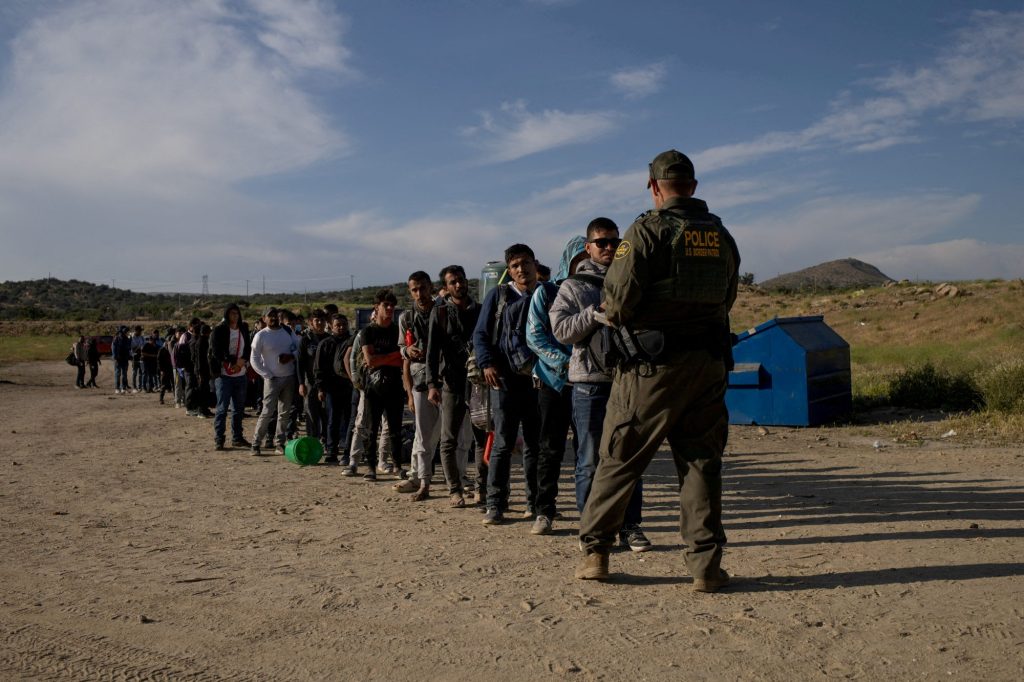 Male migrants from Jordan, China, Egypt and Colombia surrender to a border patrol agent after crossing into the U.S. from Mexico on May 15, 2024.