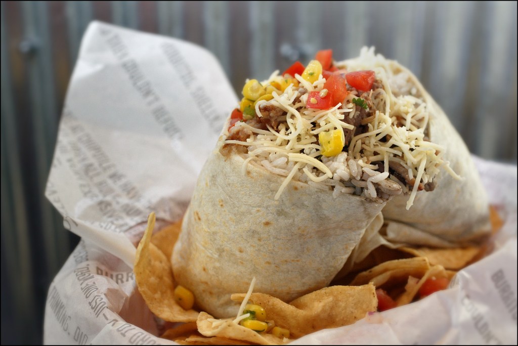 Giant burrito filled with meat and vegetables at a Chipotle restaurant location