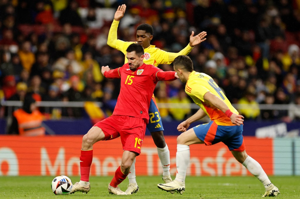 Romania defender Andrei Burca fights for the ball against Colombia.