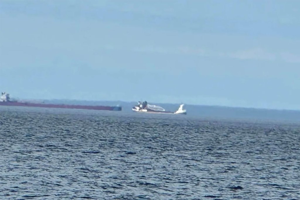 A 689-foot freighter ship, right, began taking on water Saturday morning after it hit an underwater obstacle in Lake Superior, forcing about half of the 22 people on board to evacuate, the U.S. Coast Guard said.