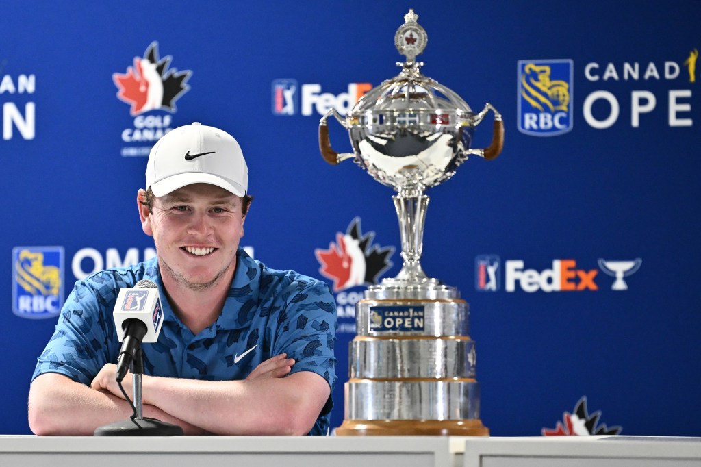 Robert MacIntyre next to the trophy he won.