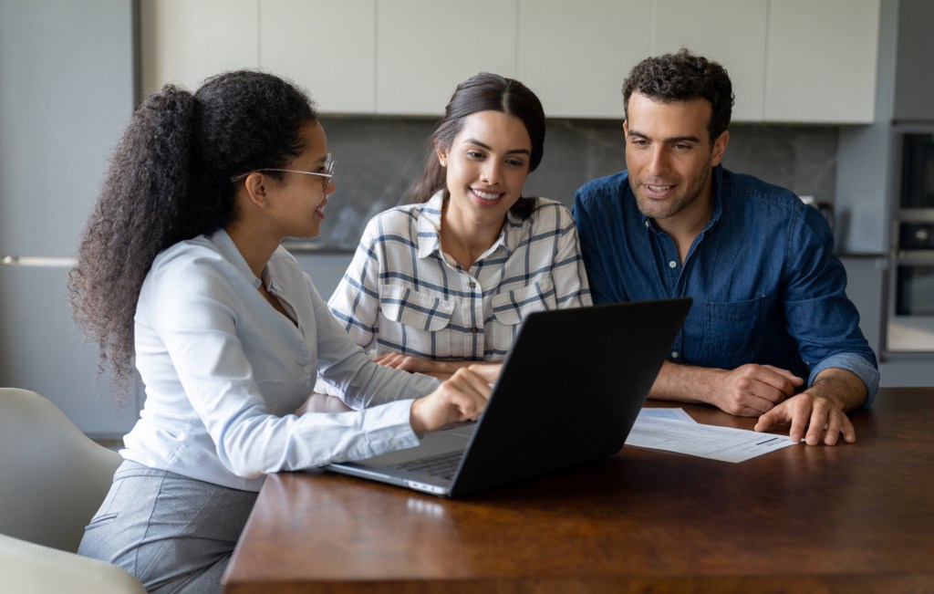 Latin American couple, including Jason Canela, discussing with a financial advisor over a laptop about home investment concepts