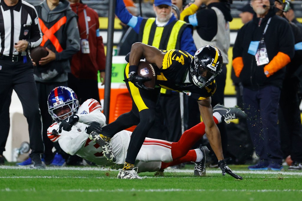 George Pickens #14 of the Pittsburgh Steelers avoids a tackle from Deonte Banks #3 of the New York Giants