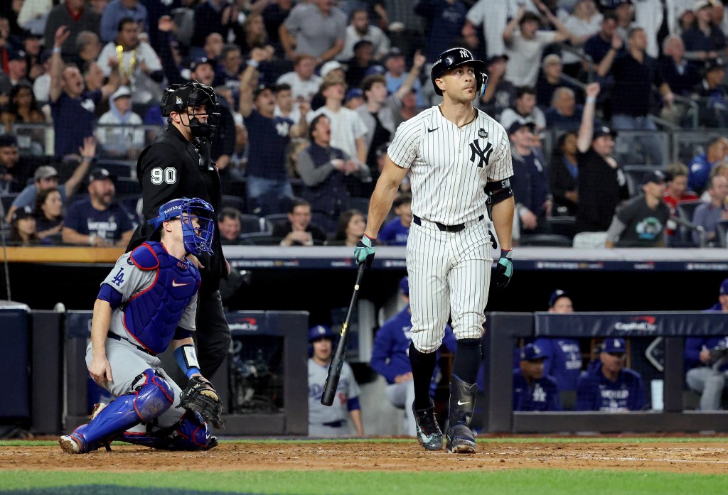 Yankees designated hitter Giancarlo Stanton #27 hits a solo home run during the third inning.