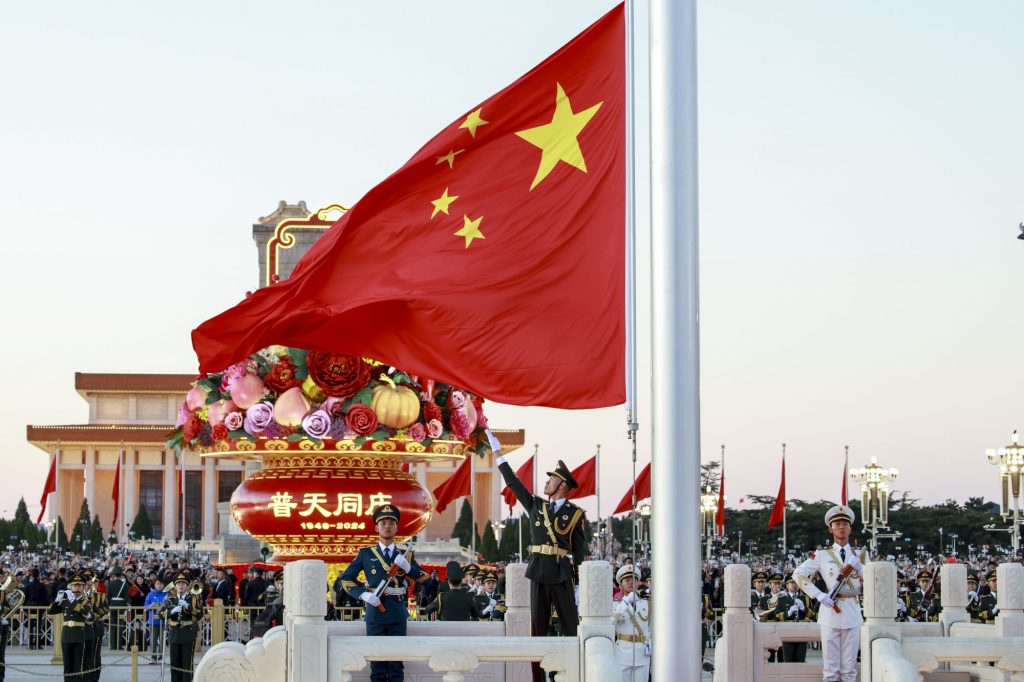 A flag bearer unfurls the Chinese national flag during a flag-raising ceremony at Tian'anmen Square on October 1, 2024 in Beijing, China.