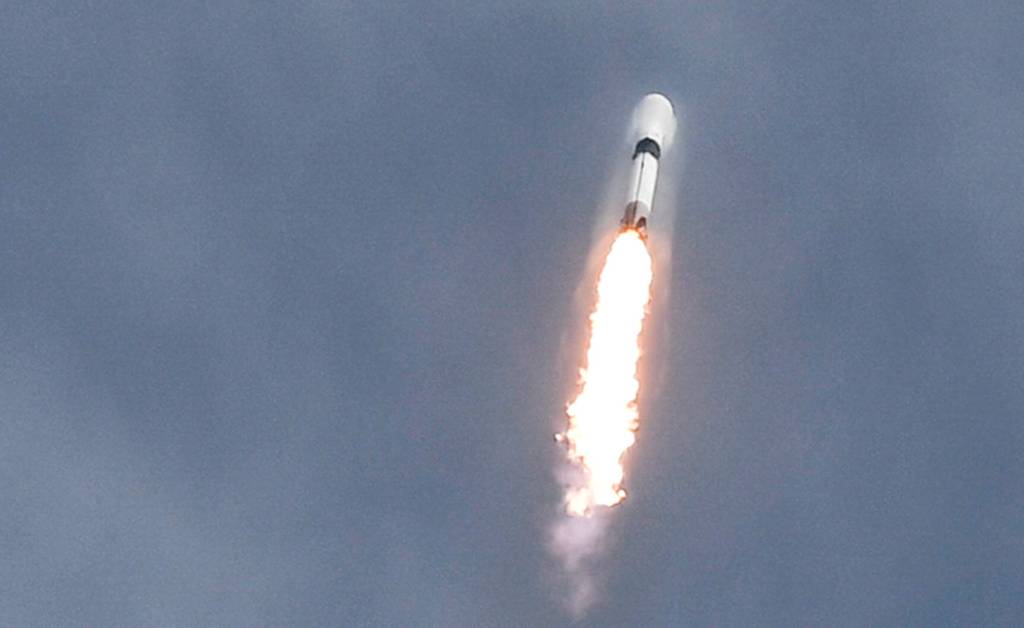 SpaceX Falcon 9 rocket launching from Cape Canaveral with a vapor cone developing around it, carrying 23 Starlink satellites