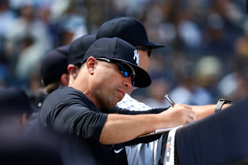 Assistant Pitching Coach, Desi Druschel of the New York Yankees looks on during the game against the Texas Rangers at Yankee Stadium on August 11, 2024, in New York, New York