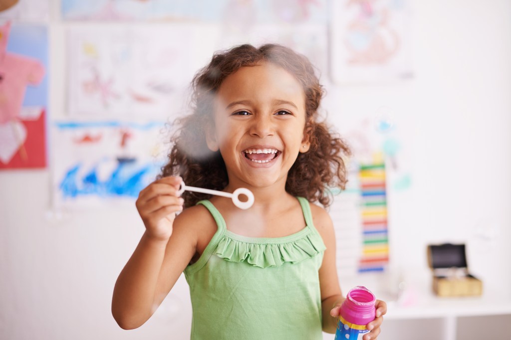 little girl blowing bubbles in classroom