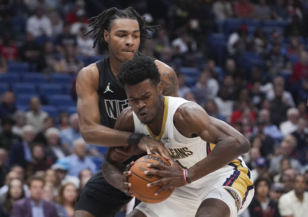 Noah Clowney plays tough defense on a Pelicans player during the Nets' win.