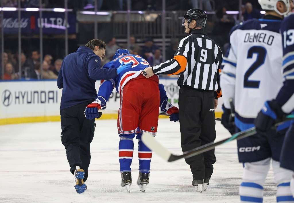 Mika Zibinejad is checked by a referee and trainer during the second period. 