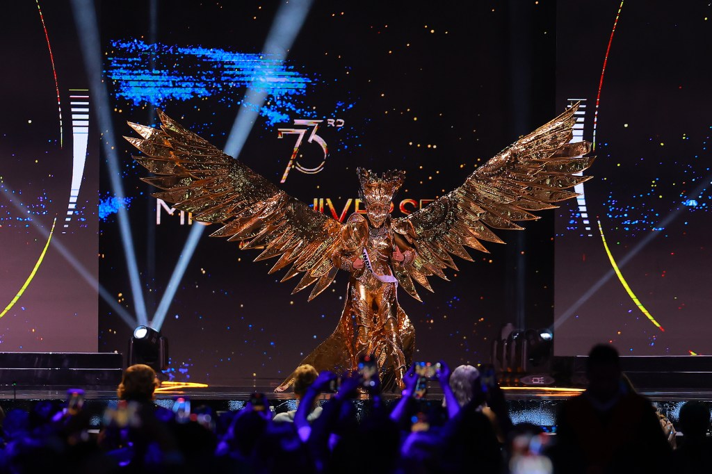 Miss India Rhea Singha wearing a gold garment with wings, participating in the 73rd Miss Universe Preliminary Competition in Mexico City