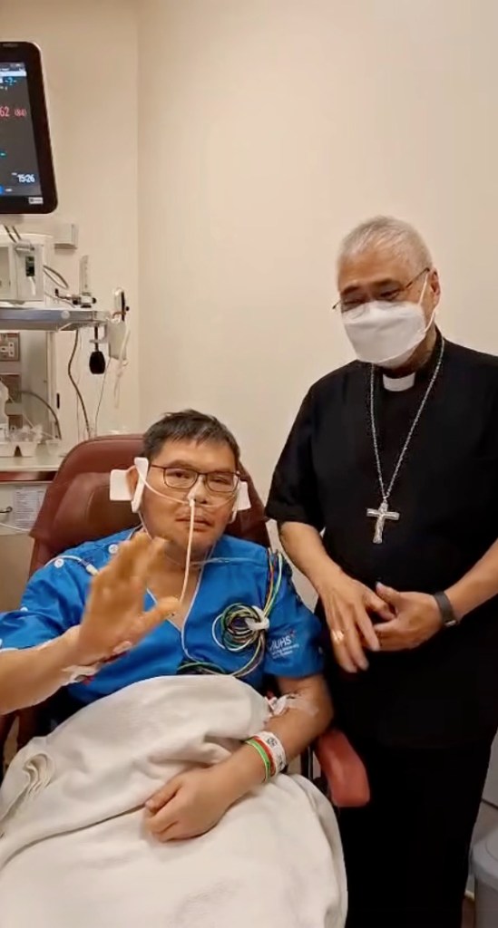 Father Christopher Lee and Cardinal William Goh in the hospital after the former was injured in a church attack