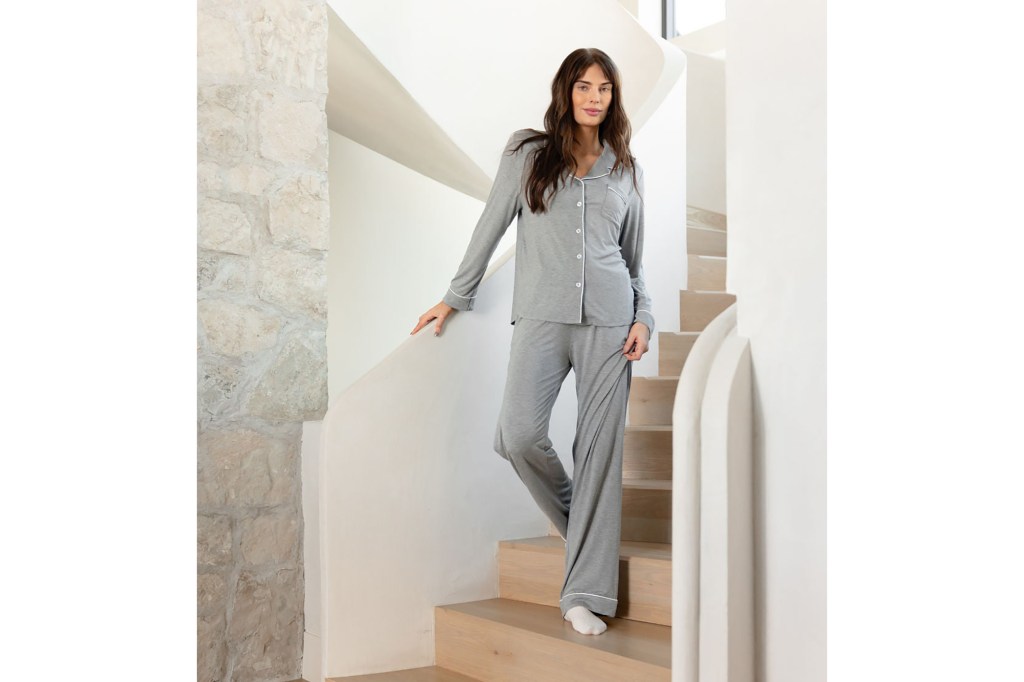 woman in pajamas standing on a staircase