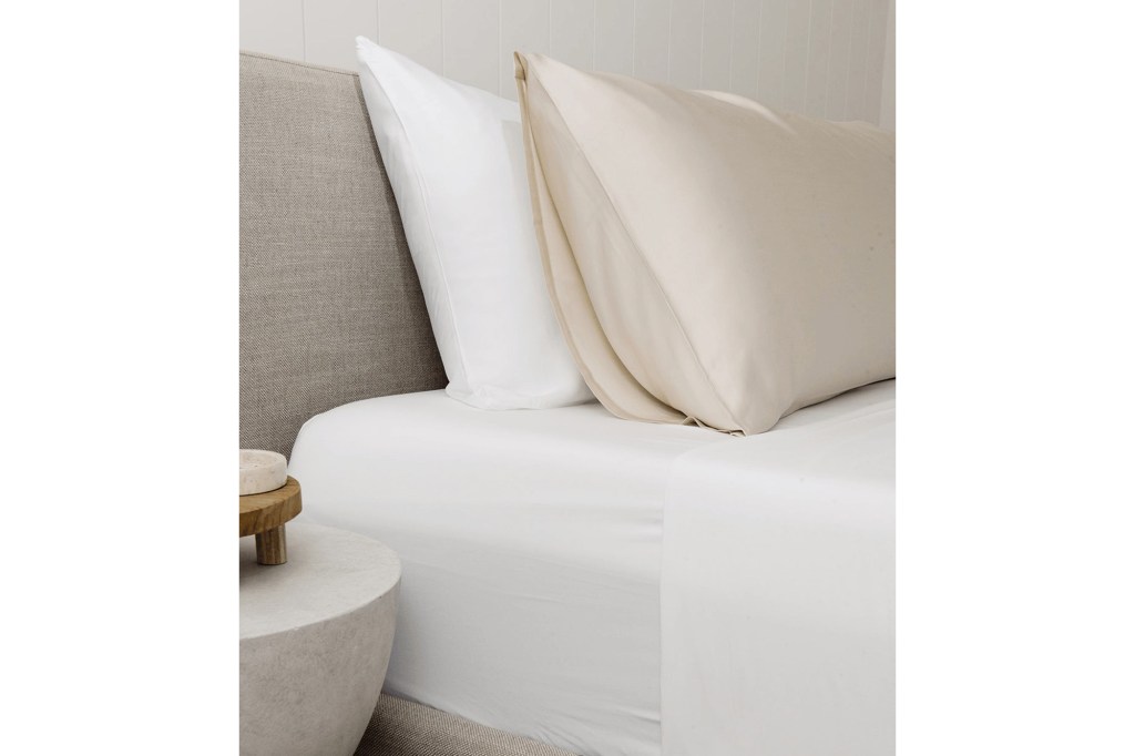 A bed with white sheets and pillows