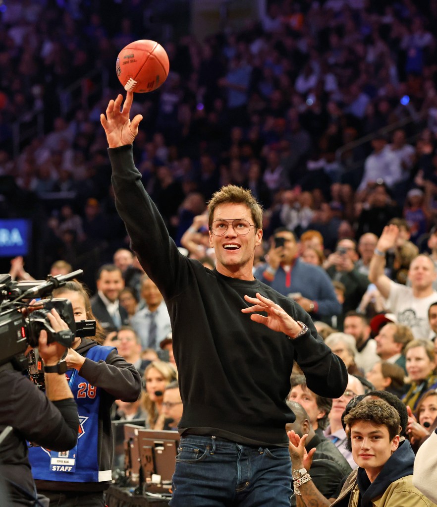 NFL great Tom Brady throws a football into the stands from celebrity row in the first half at the Madison Square Garden in New York. 