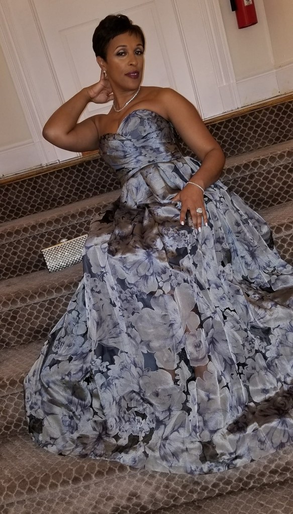 Lieutenant Quathisha Epps, the top earner of NYPD, sitting on stairs in a dress