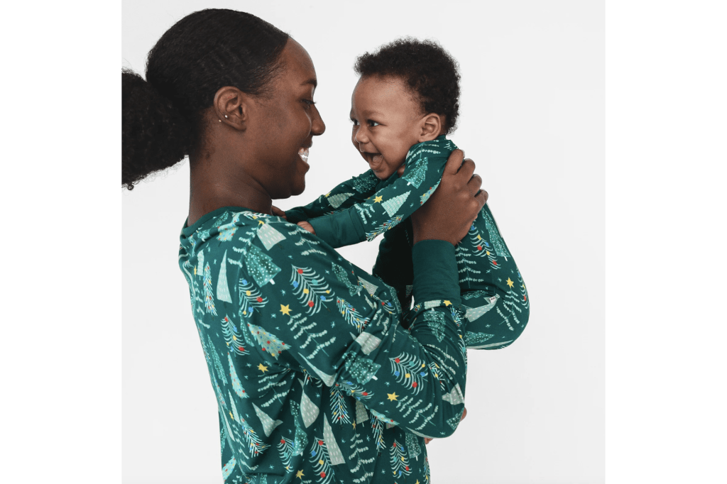 Mom holding baby in matching Christmas pajamas