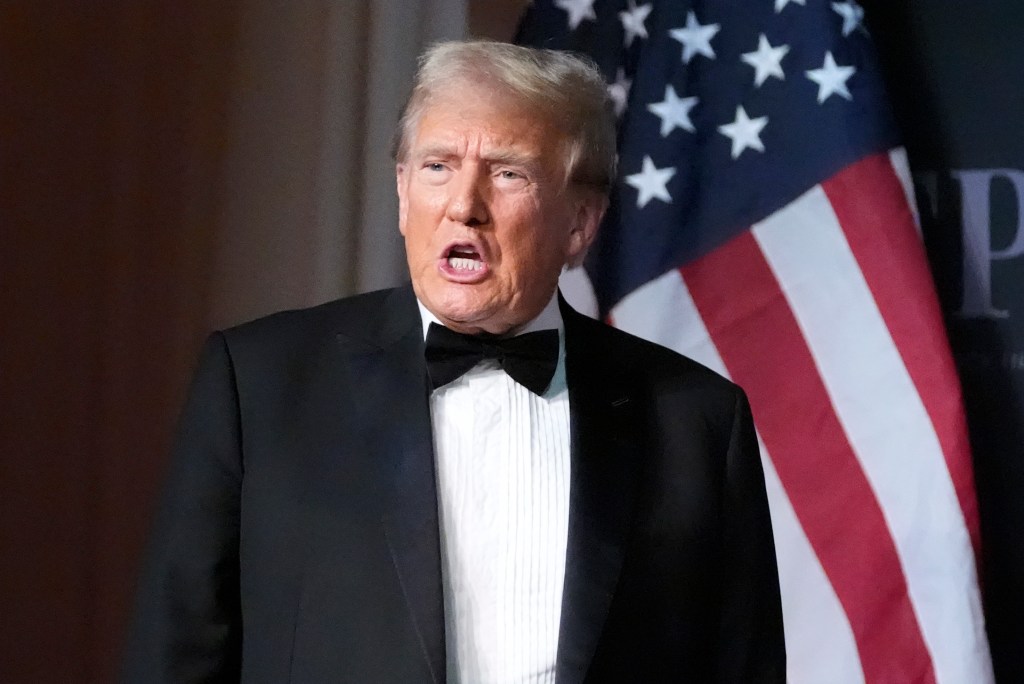 Donald Trump in a tuxedo with an American flag behind him.