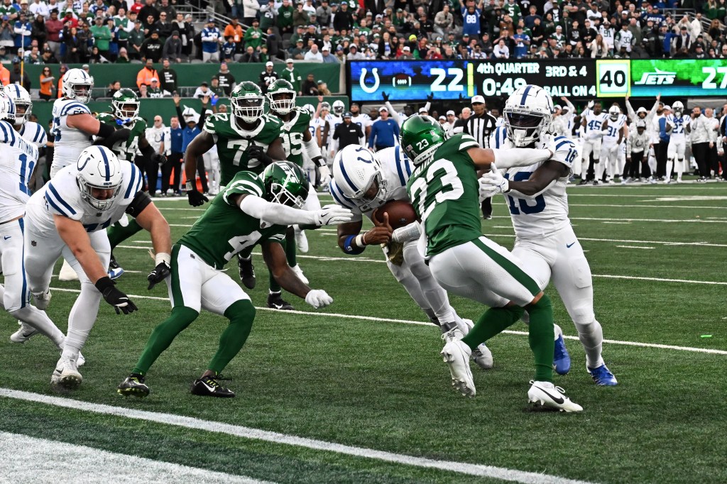 Anthony Richardson (5) barrels through Jets cornerbacks D.J. Reed (4) and Isaiah Oliver (23) to score a touchdown in the fourth quarter. 