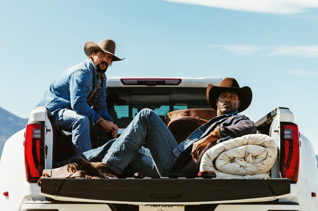 Men in cowboy hats sitting in the back of a truck