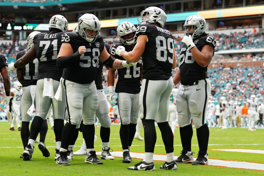 Jakobi Meyers #16 and Brock Bowers #89 of the Las Vegas Raiders celebrate with teammates after Bowers' receiving touchdown in the third quarter of a game at Hard Rock Stadium on November 17, 2024 in Miami Gardens, Florida.