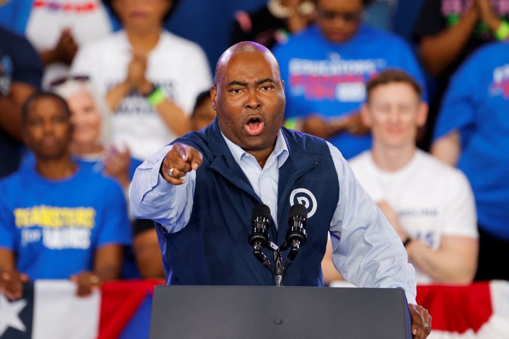 Jaime Harrison, chair of the Democratic National Committee, speaking at a podium during a Kamala Harris campaign event in Charlotte, North Carolina